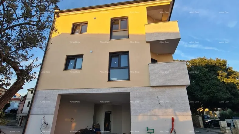 Neubau-Mehrfamilienhaus mit moderner Architektur und Balkonen, umgeben von einer Baustelle.
