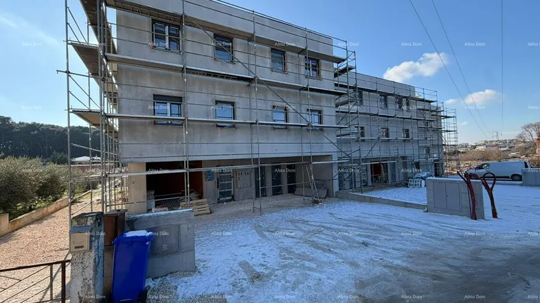 Neubau im Rohbauzustand mit Gerüst und Schnee auf dem Gelände, bereit für den weiteren Ausbau.