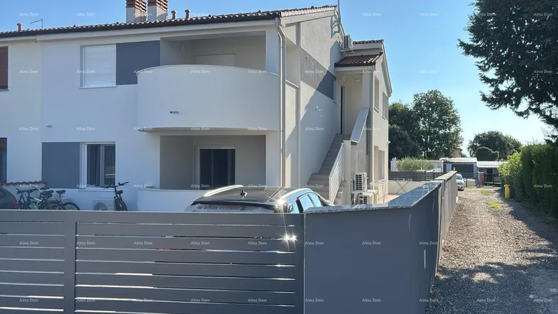 Moderne Wohnanlage mit weißer Fassade, Balkonen und einem gepflegten Eingangsbereich.