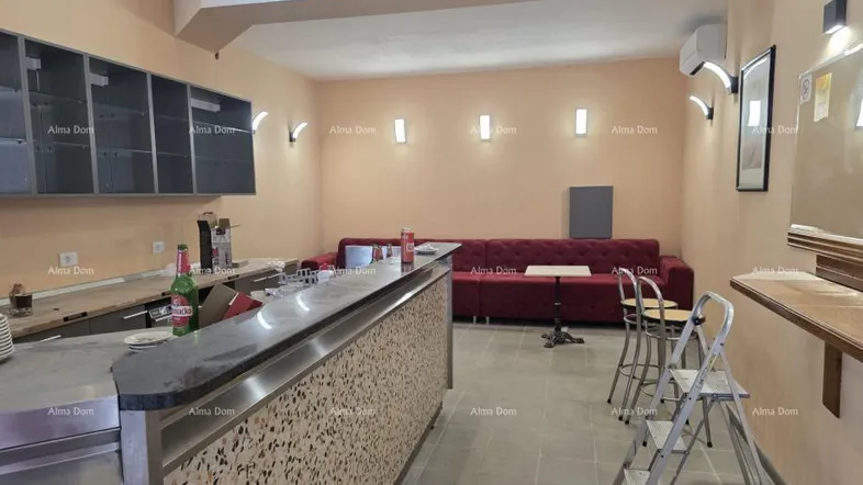 Innenbereich einer Bar oder Lounge mit Theke, Sitzgelegenheiten und Regalen, bereit zur Nutzung.