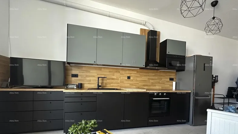 Moderne Küche mit schwarzen Unterschränken, grauen Oberschränken und Holzakzenten.