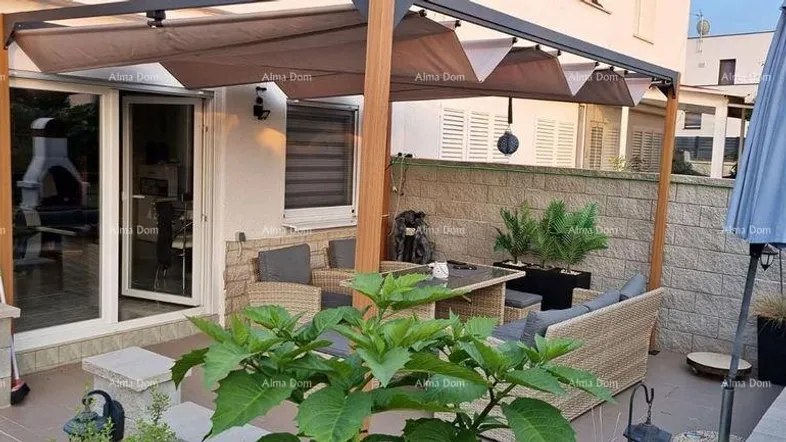 Gemütliche Außenterrasse mit Pergola, Sitzgelegenheiten und Sonnenschirm für entspannte Stunden im Freien.