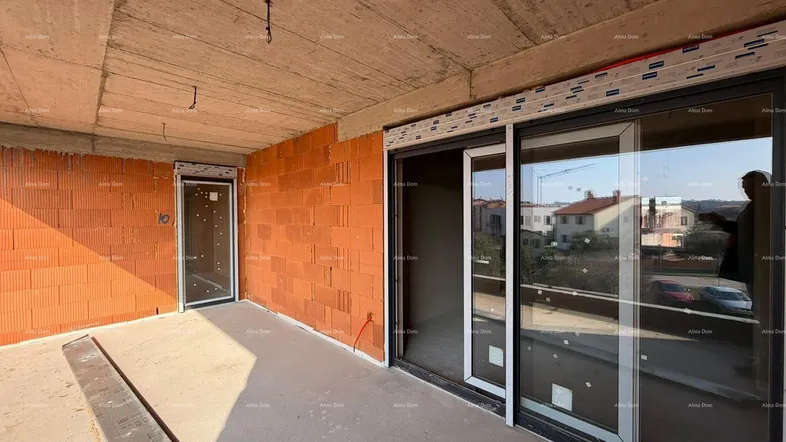Unfertiger Balkon mit unverputzten Ziegelwänden und großen Schiebetüren, die viel Licht hereinlassen.