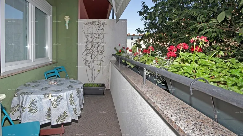 Gemütlicher Balkon mit Tisch und Stühlen, umgeben von Pflanzen und Blumenkästen.