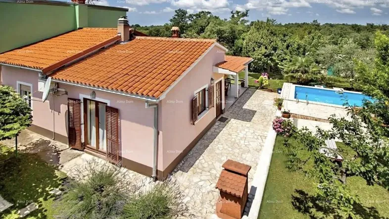 Luftaufnahme eines Hauses mit Pool, gepflastertem Weg und üppigem Grün in ländlicher Umgebung.