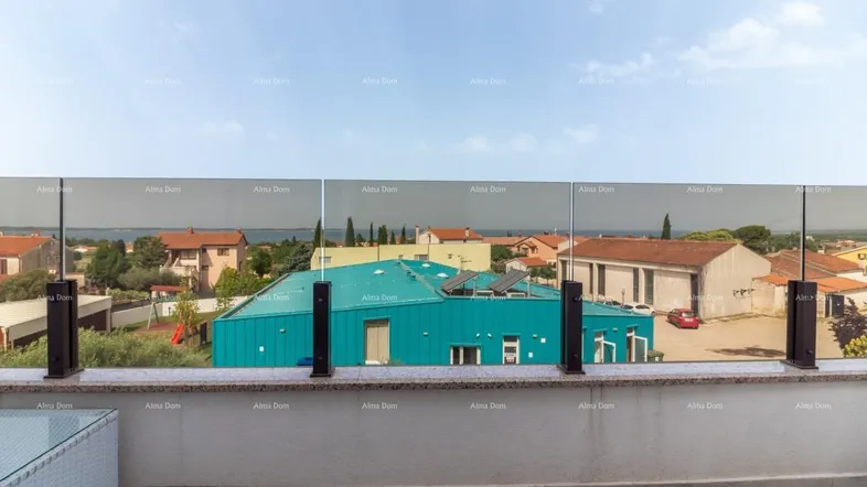 Große Terrasse mit Glasgeländer und weitem Blick über die Dächer der Umgebung bis zum Meer.