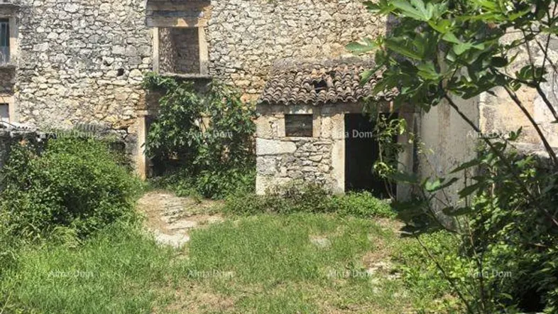 Altes, verfallenes Steingebäude mit überwuchertem Gartenbereich und teilweise eingestürztem Dach.