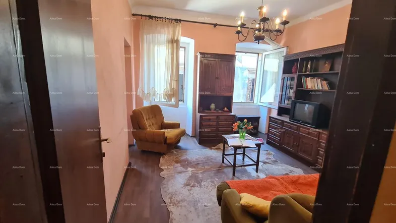 Gemütliches Wohnzimmer mit traditionellen Holzmöbeln, Parkettboden und einem dekorativen Kuhfellteppich.