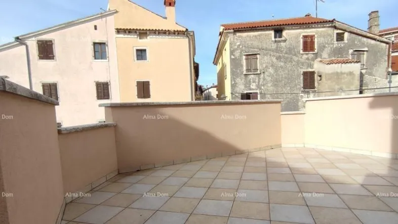Geräumige Dachterrasse mit Fliesenboden und Blick auf die umliegenden Gebäude.