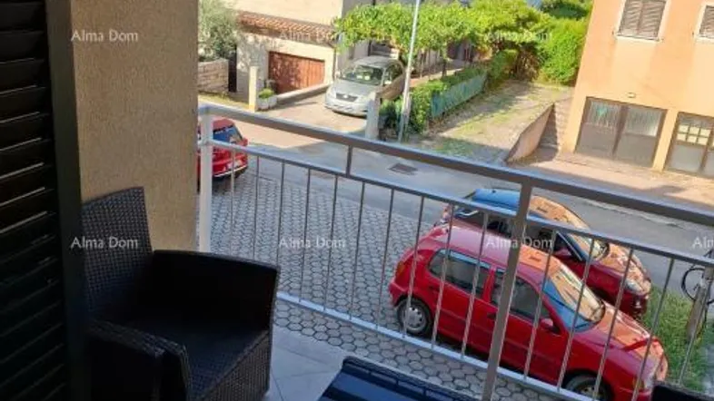 Möblierter Balkon mit Blick auf die Straße und umliegende Gebäude, inklusive Klimaanlage.