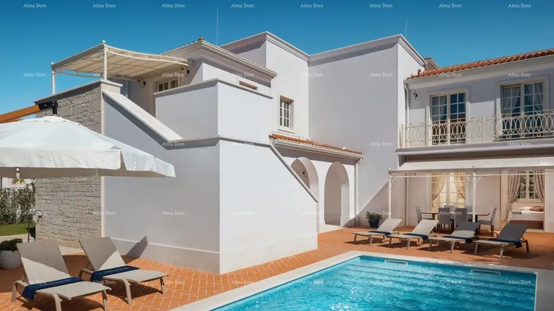 Luxuriöse Villa mit großem Poolbereich, Liegestühlen und einer sonnigen Terrasse.