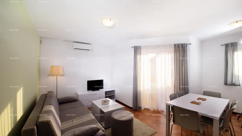 Helles Wohn- und Esszimmer mit beigem Sofa, Esstisch und Klimaanlage.