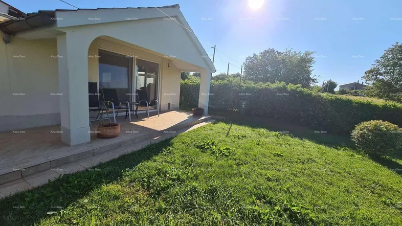 Sonnige Terrasse mit Sitzgelegenheiten und Blick auf den gepflegten Gartenbereich des Hauses.