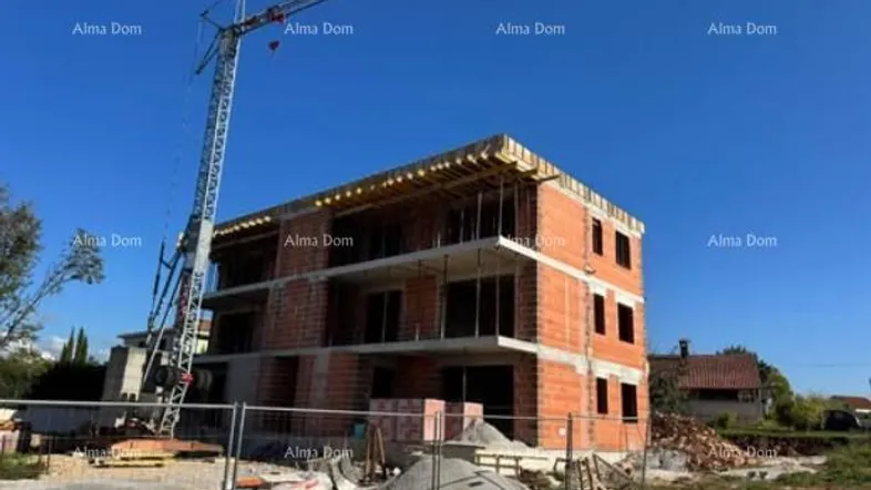 Neubau im Rohbauzustand mit sichtbaren Ziegelwänden und Baukran auf der Baustelle.