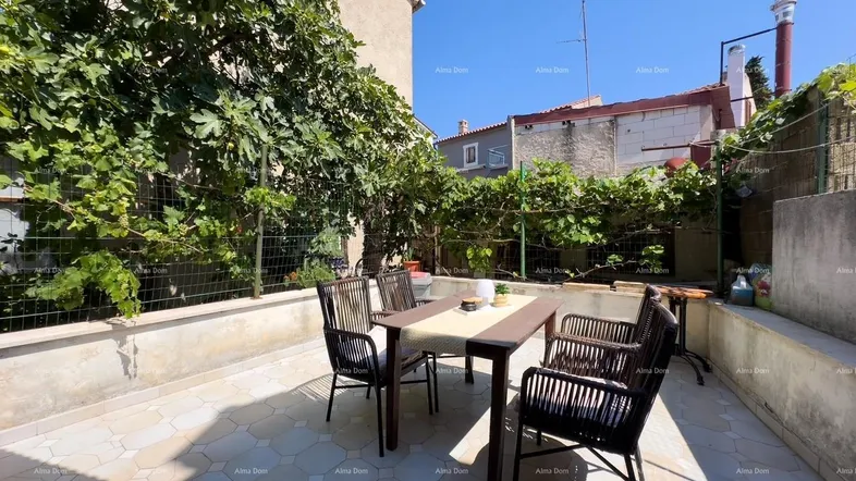 Gepflasterte Terrasse mit Gartenmöbeln und üppiger Begrünung, ideal für Mahlzeiten im Freien.