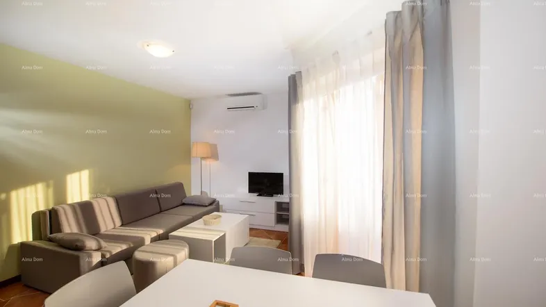 Helles Wohn- und Esszimmer mit bequemer Couch, Esstisch und Klimaanlage.