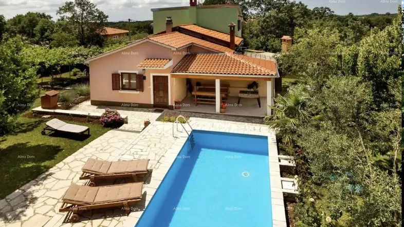 Luftaufnahme eines Hauses mit privatem Pool, Sonnenliegen und weitläufigem Gartenbereich.
