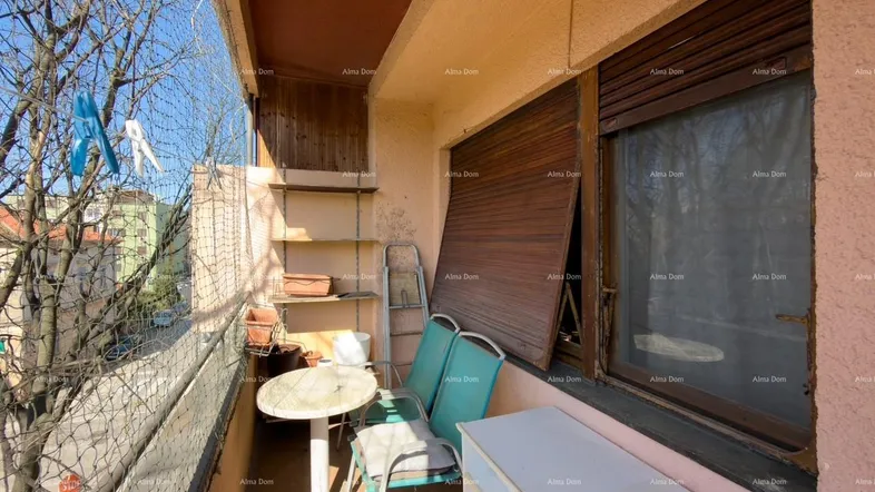 Gemütlicher Balkon mit Sitzgelegenheiten, Regalen und Schutznetz, ideal für entspannte Stunden im Freien.