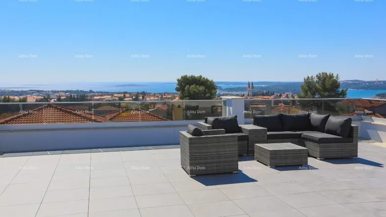 Große Dachterrasse mit bequemen Loungemöbeln und weitem Blick über die Stadt und das Meer.