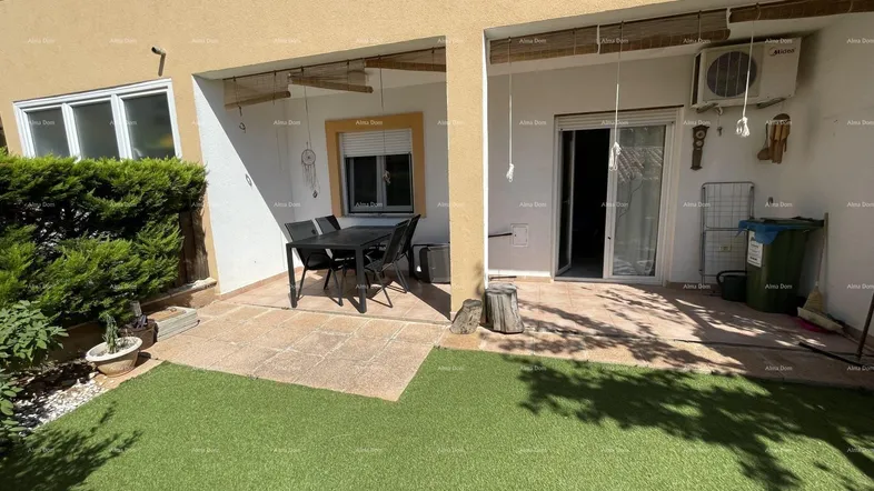 Geräumige Terrasse mit Kunstrasenfläche und überdachtem Essbereich, ideal für Mahlzeiten im Freien.