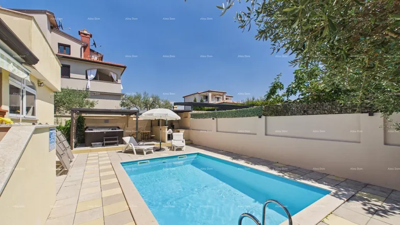 Außenbereich mit privatem Swimmingpool, Sonnenliegen und einem Whirlpool unter einer Pergola an einem sonnigen Tag.