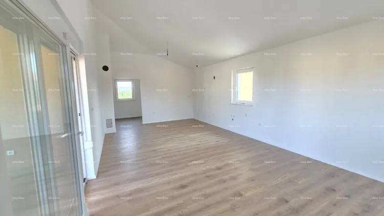Geräumiger, heller Wohnbereich mit neuem Laminatboden und Zugang zu einem Außenbereich.