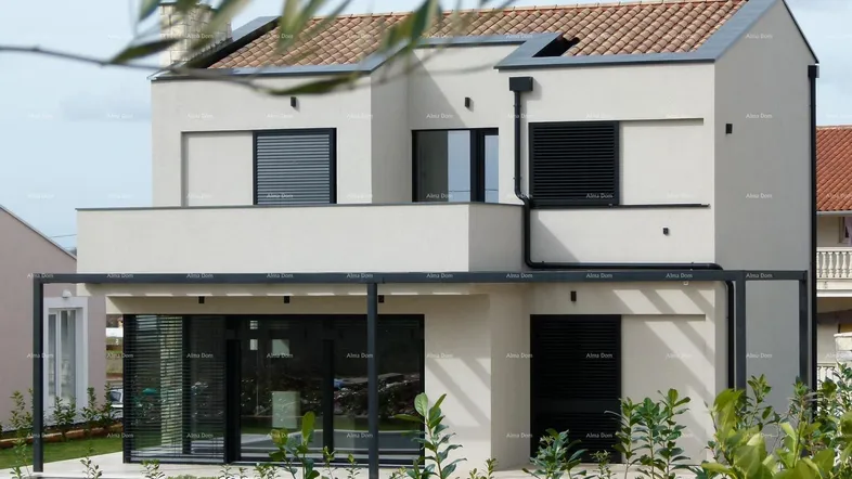 Moderne Hausfassade mit großen Fenstern, Rollläden und einem Vordach über der Terrasse.