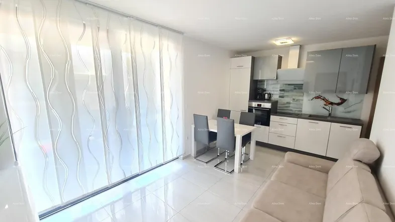 Heller offener Wohn-Essbereich mit moderner Küche, Fliesenboden und Zugang zu einem Balkon.