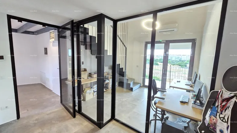 Modernes Büro mit Glaswänden, Schreibtisch und Zugang zu einem Balkon mit Weitblick.