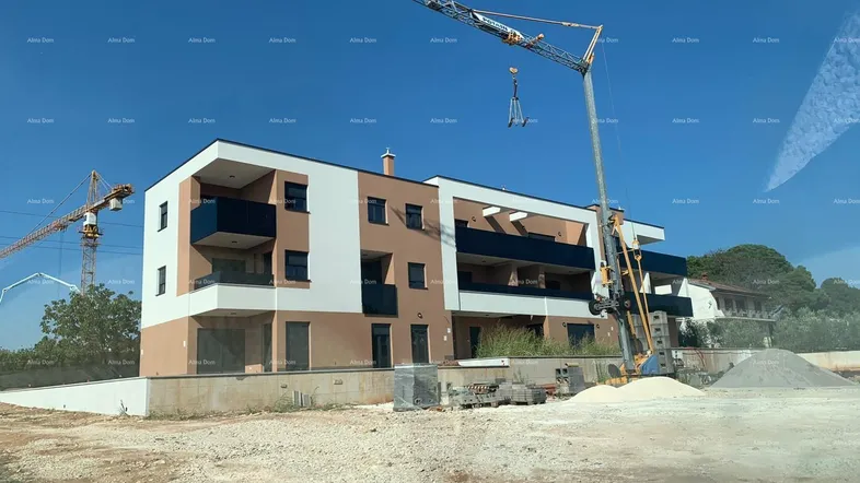 Neubau eines modernen Wohngebäudes mit Balkonen und Kränen auf der Baustelle.