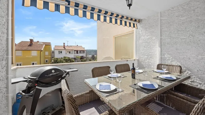 Geräumiger Balkon mit Esstisch, Grill und Markise, ideal für Mahlzeiten im Freien mit Blick auf die Umgebung.