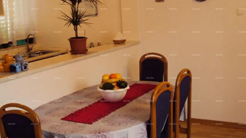 Essbereich mit Holzboden und einem Tisch mit Stühlen, angrenzend an eine Küchenzeile.