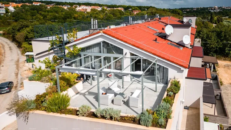 Dachterrasse mit Pergola, Gartenmöbeln und Blick auf die Umgebung, umgeben von mediterraner Vegetation.