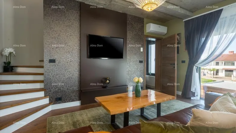 Modernes Wohnzimmer mit Holztisch, Ledersofa und Treppenzugang, beleuchtet von einer auffälligen Deckenleuchte.