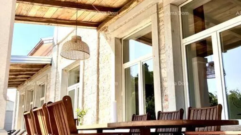 Überdachte Terrasse mit Holztisch und Stühlen, ideal für Mahlzeiten im Freien.