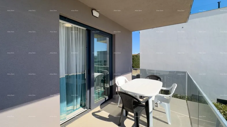 Heller Balkon mit Glasgeländer und Sitzgelegenheiten, ideal für entspannte Stunden im Freien.