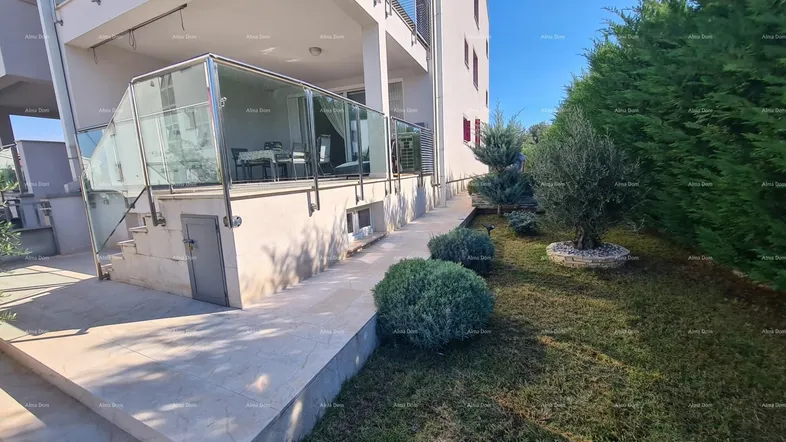 Außenansicht des Gebäudes mit gepflegtem Gartenbereich und Zugang zu einer Terrasse.