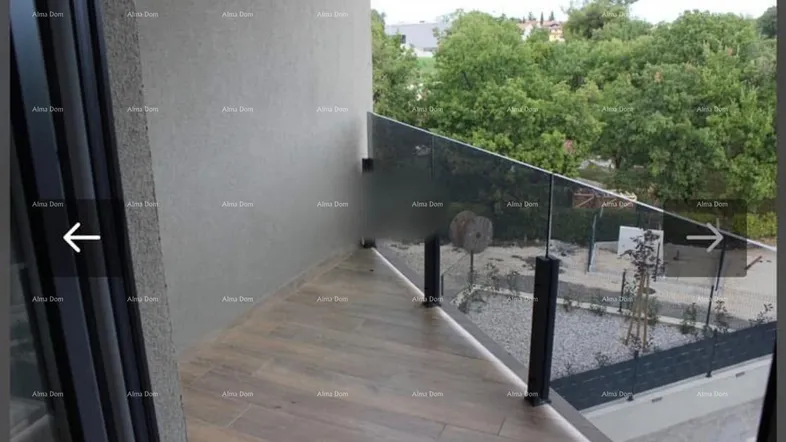 Moderner Balkon mit Glasgeländer und Blick ins Grüne, ideal zum Entspannen.