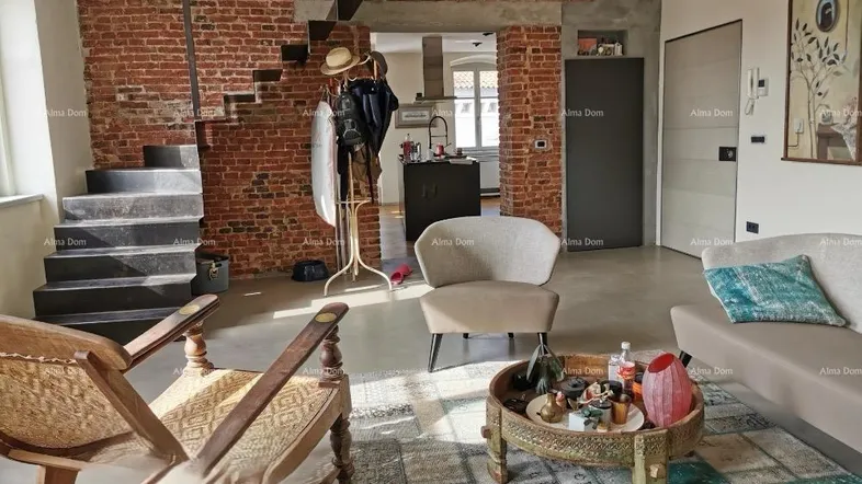 Geräumiges Wohnzimmer mit freiliegenden Ziegelwänden, moderner Treppe und gemütlicher Sitzecke.