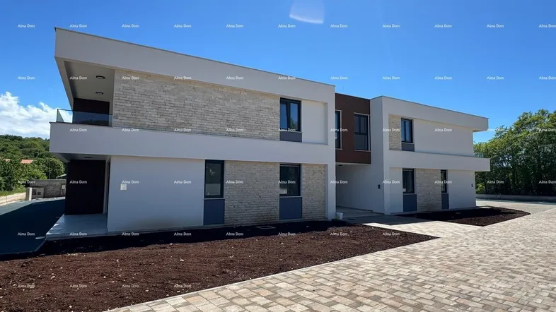Moderne Wohnanlage mit heller Fassade, Steinverkleidung und großen Fenstern.