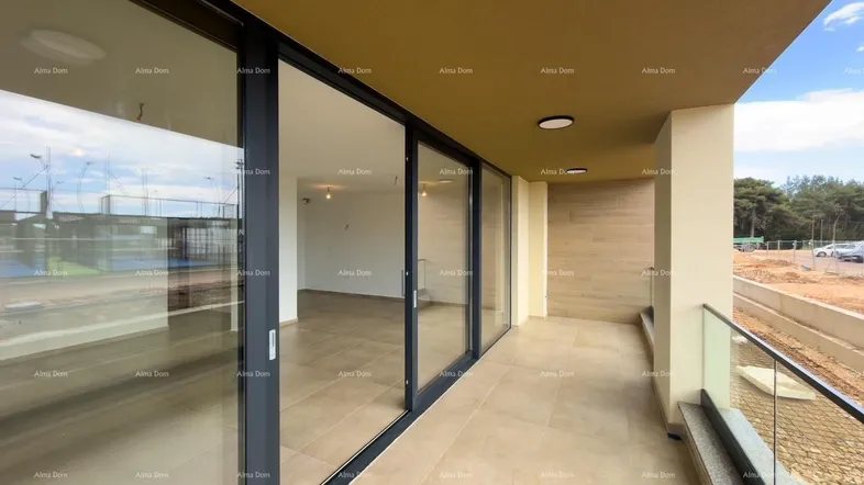 Geräumiger Balkon mit Fliesenboden und großen Glasschiebetüren, die zum Innenbereich führen.