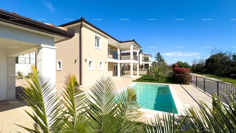 Außenansicht des Hauses mit einem erfrischenden Swimmingpool und mediterraner Bepflanzung unter blauem Himmel.