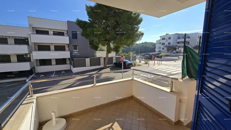 Heller Balkon mit Fliesenboden und Blick auf die Straße sowie umliegende Gebäude.