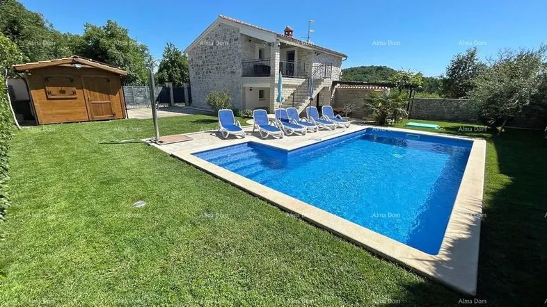 Steinhaus mit privatem Pool, Liegestühlen und gepflegtem Rasen im sonnigen Gartenbereich.