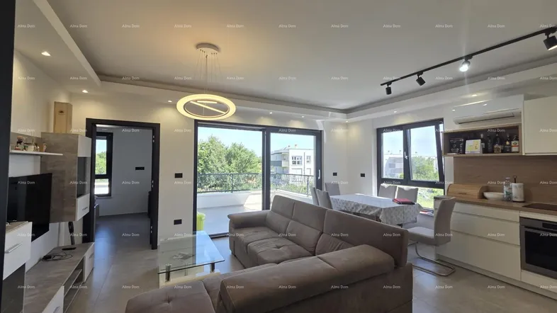 Moderner offener Wohn-Essbereich mit integrierter Küche, bequemer Couch und Zugang zum Balkon.