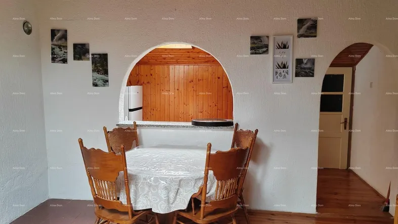 Gemütlicher Essbereich mit Holzboden und Durchgang zu einem weiteren Raum, unter einer Holzdecke.