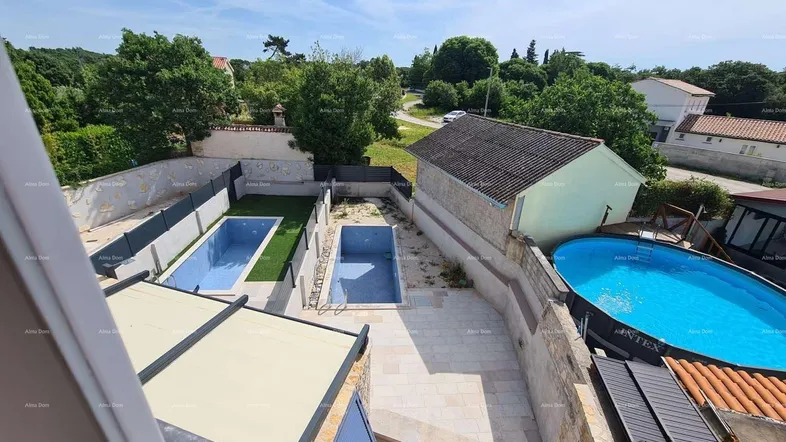 Luftaufnahme des Anwesens mit mehreren Pools, umgeben von viel Grün und weiteren Gebäuden.