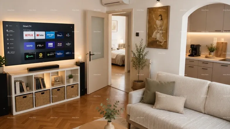 Helles Wohnzimmer mit Parkettboden, Smart-TV und offener Verbindung zur Küche.