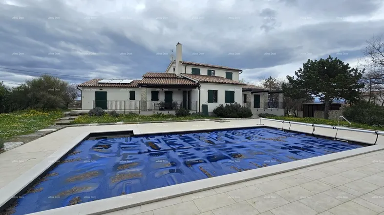 Großzügiges Anwesen mit einem weitläufigen Poolbereich und einem charmanten Landhaus unter bewölktem Himmel.