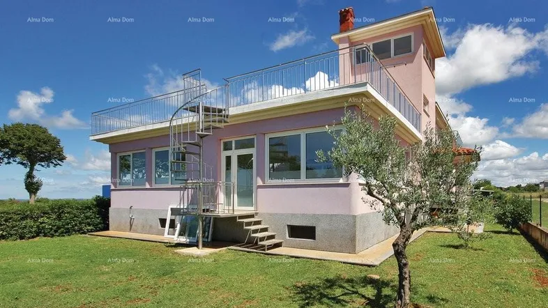 Rosa gestrichenes Haus mit Außentreppe und Dachterrasse, umgeben von einem grünen Garten.